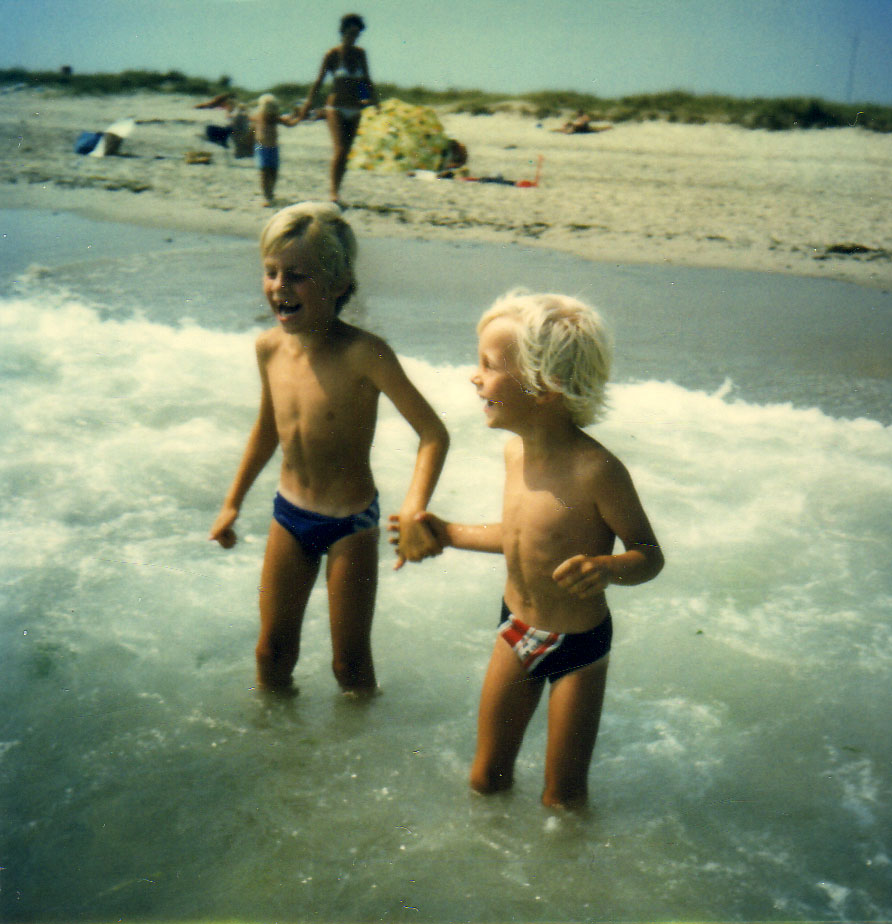 Me and my brother, that is walking into the waves at the beach of Skagen. The famous parasol of my grand parents are seen in the background.